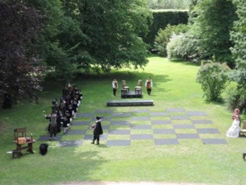 В Крумловском парке происходит начало шахматной партии (выход команды черных фигур) -megatour.cz